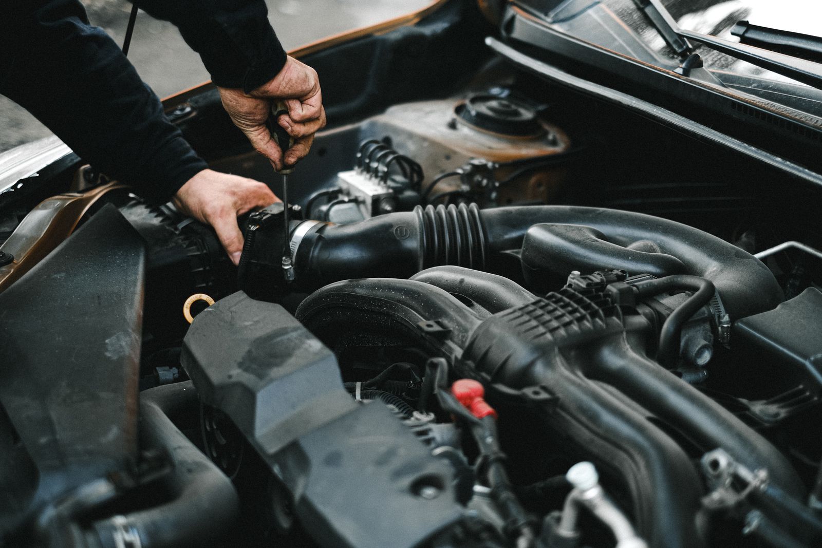 Technician's hands working on a car engine